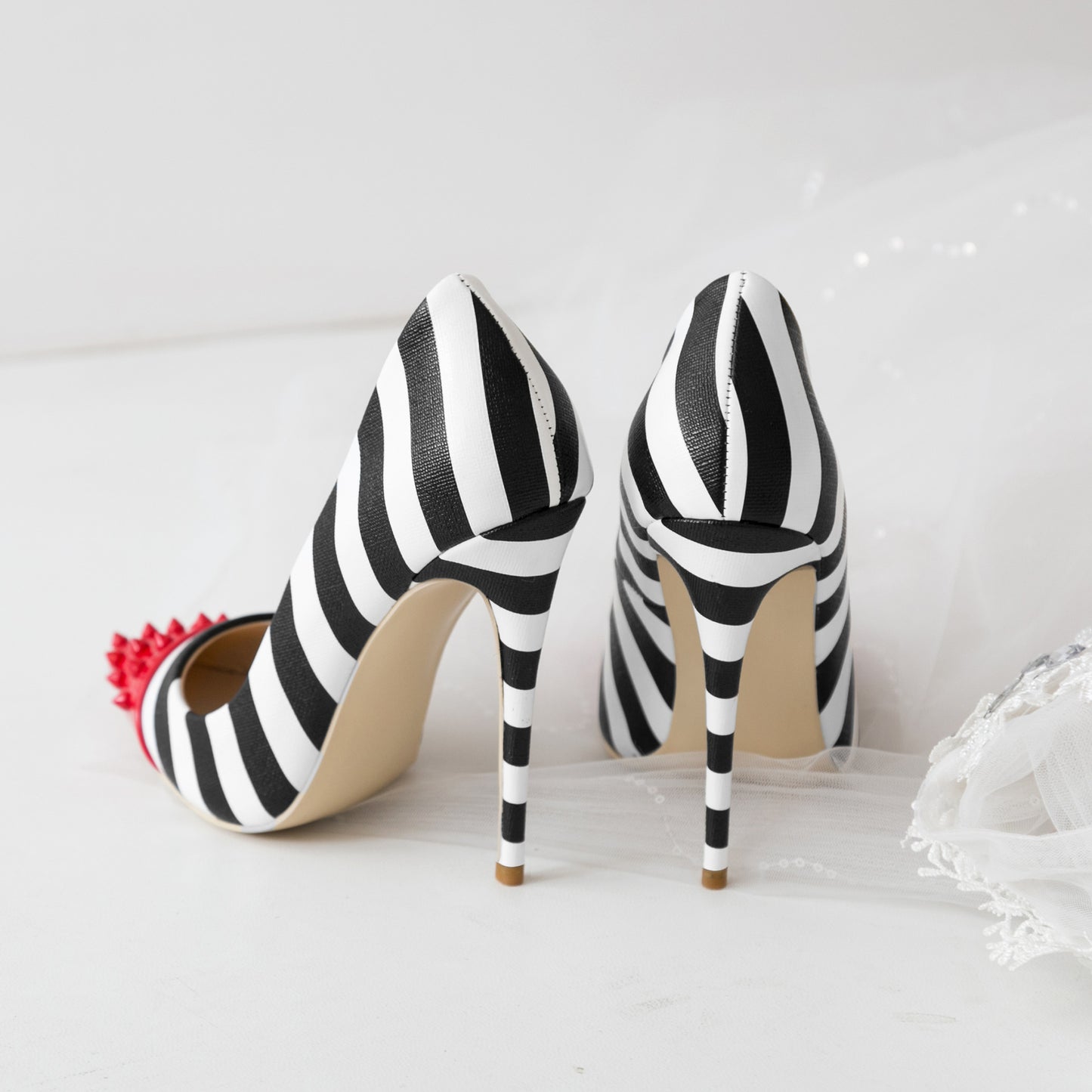 Black and white striped high-heeled shoes on a white background