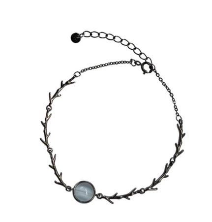 A silver-toned branch wreath bracelet featuring a round, light blue-gray stone pendant, displayed on a clean white background.