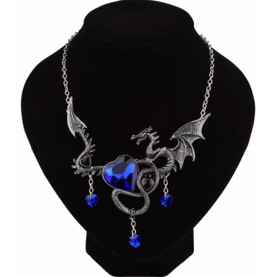 Dragon-shaped necklace with blue heart pendant on a black stand