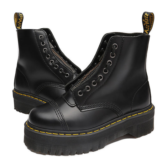 Black leather boots with yellow stitching on a white background