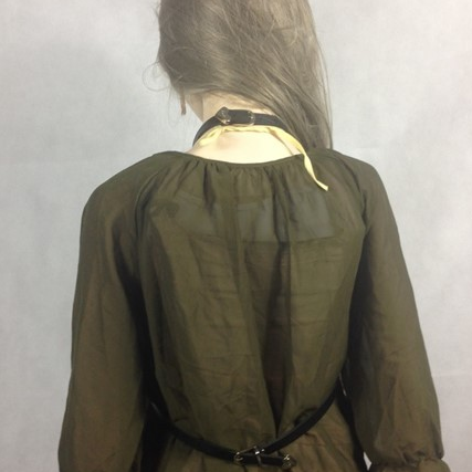 Green dress with a black belt on a plain background