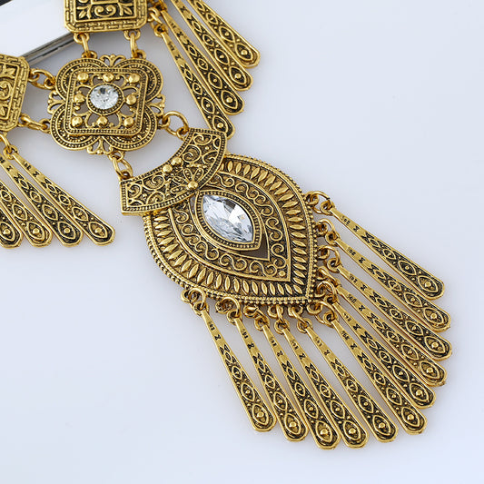 Watcher Eye gold-tone tassel necklace, ornate filigree close-up