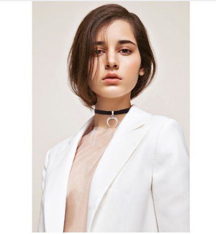 Person wearing a white blazer with a plain background