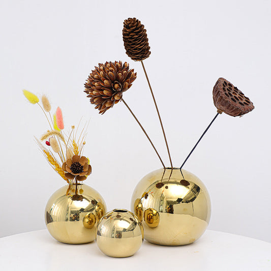 Set of gold decorative vases with natural elements on a white background
