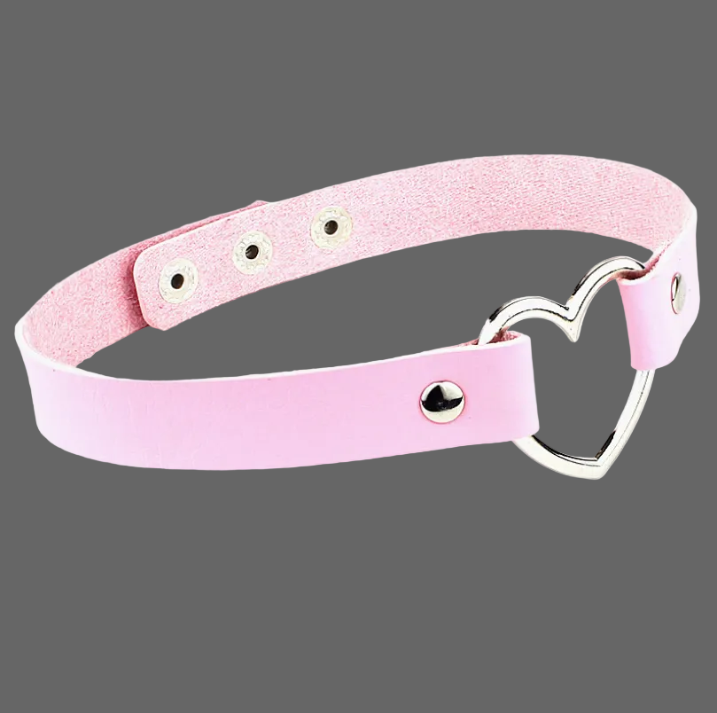 A light pink faux leather collar with a silver metal heart-shaped ring and silver rivets, displayed on a clean white background.