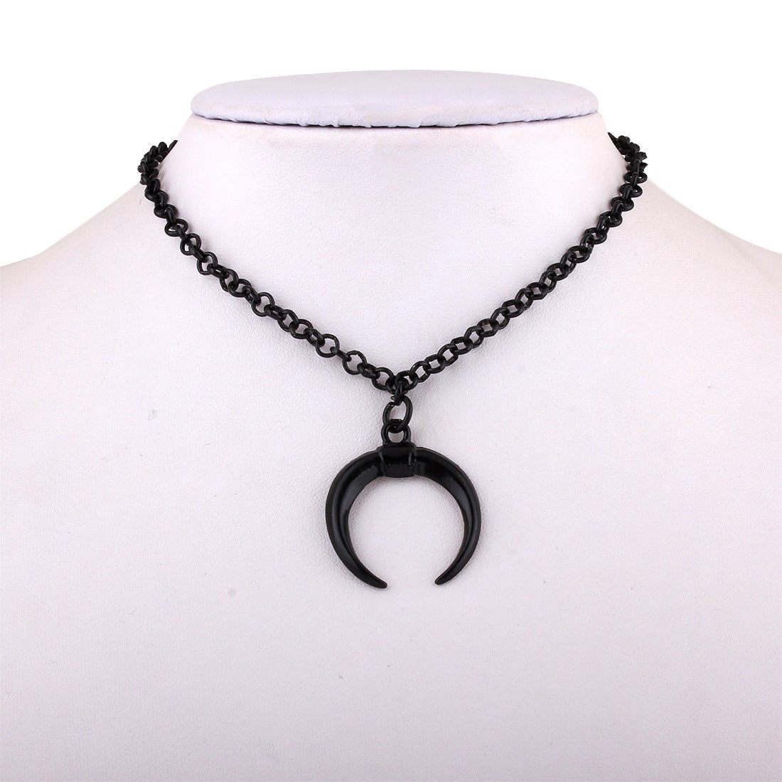 Black crescent moon necklace on a mannequin with a white background