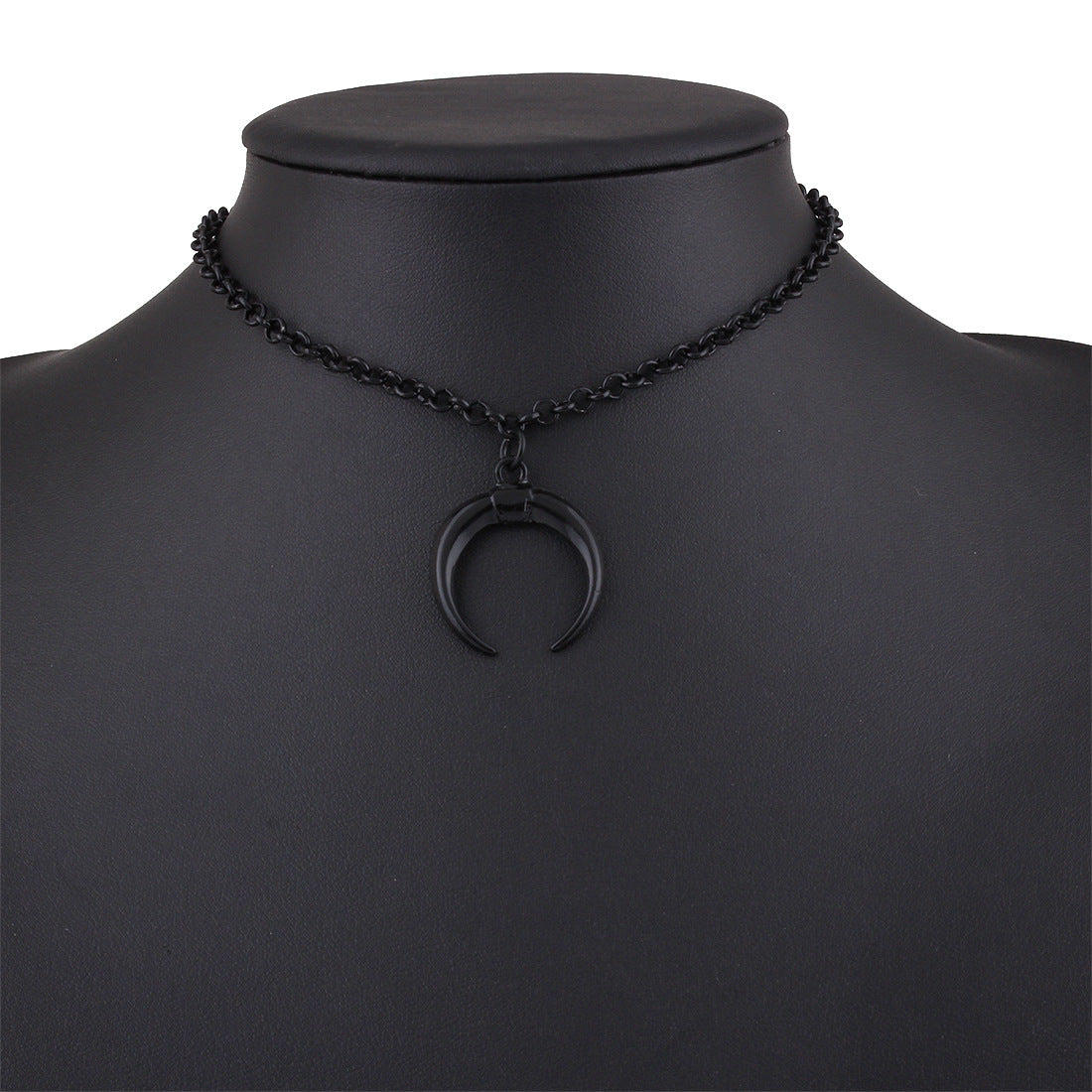 A black chain necklace with a crescent moon pendant, displayed on a matte black mannequin bust against a white background.