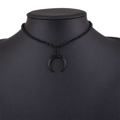 A black chain necklace with a crescent moon pendant, displayed on a matte black mannequin bust against a white background.