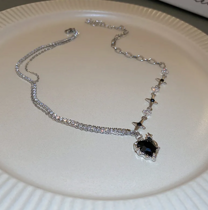 Silver necklace with a black pendant on a white plate