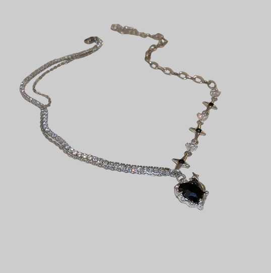 Silver necklace with a black pendant on a white plate