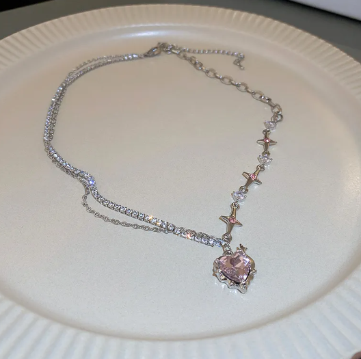 Necklace with a heart-shaped pink pendant on a white plate