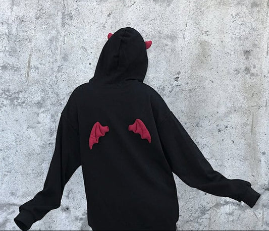 Black hoodie with red devil horns design on a concrete surface