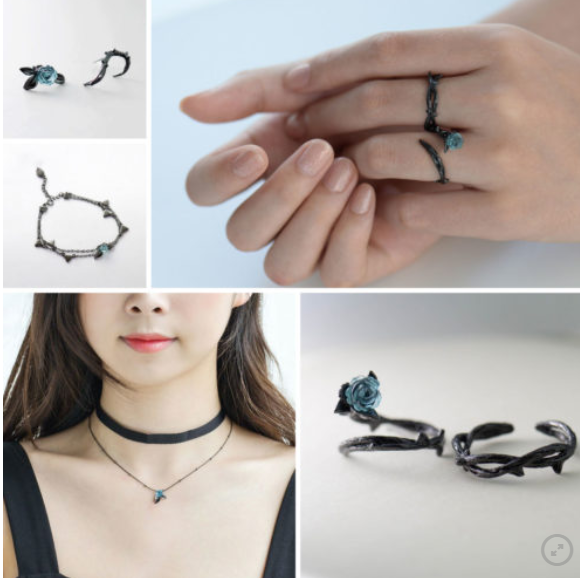A collage showing a black gothic jewelry set worn by a model and displayed individually. The set includes a ring with a small blue flower and thorn, matching stud earrings, a delicate bracelet, and a choker necklace with a small blue stone.