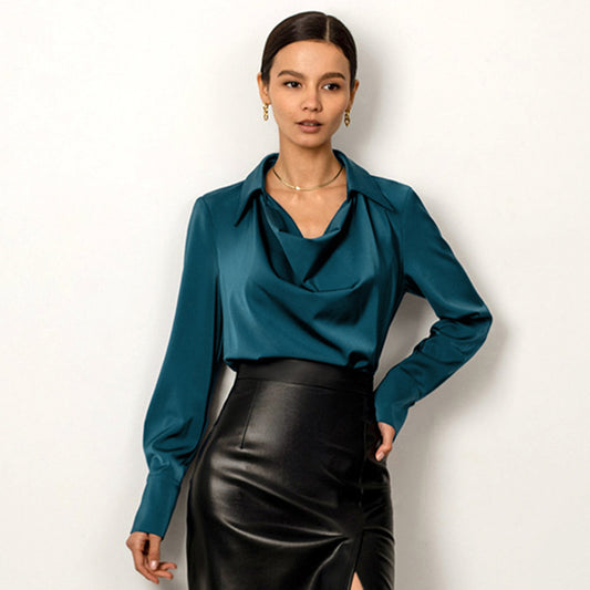 Woman wearing a teal blouse and black skirt against a white background