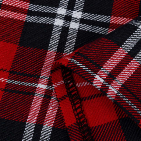 A close-up of a red, black, and white plaid fabric with a folded corner showing the woven texture.
