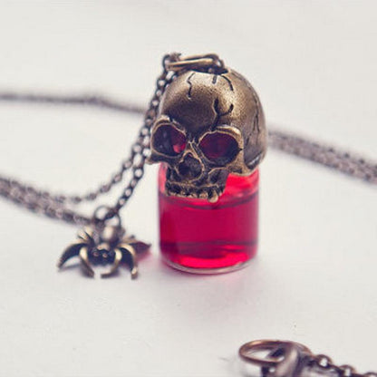 Skull-shaped pendant with red liquid and chain on a white background