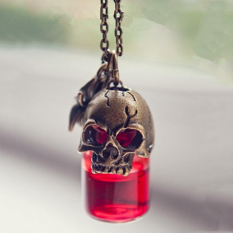 Skull-shaped pendant with red liquid inside on a blurred background