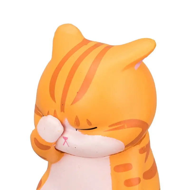 Deadpan Cat Figurine in orange, close-up view
