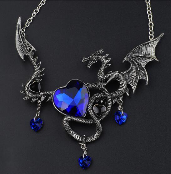 Dragon-shaped necklace with blue heart pendant on a dark background