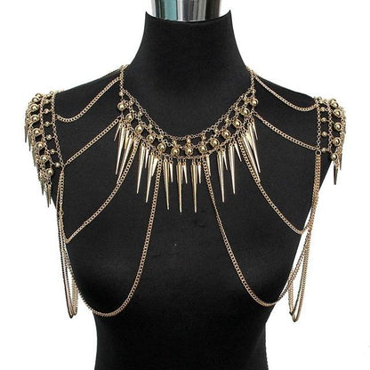 Gold chain and spike body chain on a black mannequin