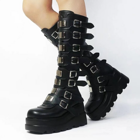 Black knee-high boots with metal buckles on a white background