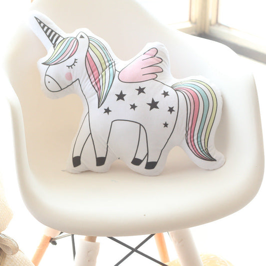 Unicorn-shaped pillow on a white chair with a blurred background