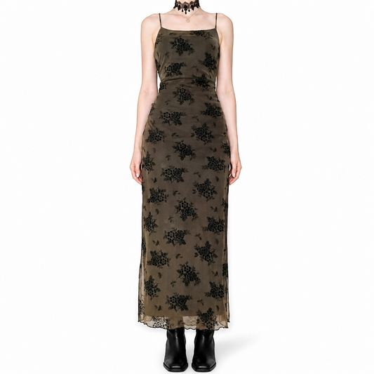 A woman modeling a long sleeveless maxi dress with a black floral lace overlay on a brown base, paired with black ankle boots and a black choker necklace, against a plain white background.