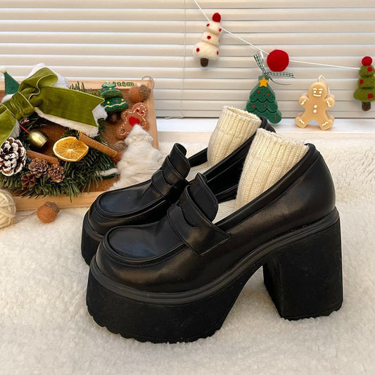 Black platform shoes on a textured surface with decorative items in the background