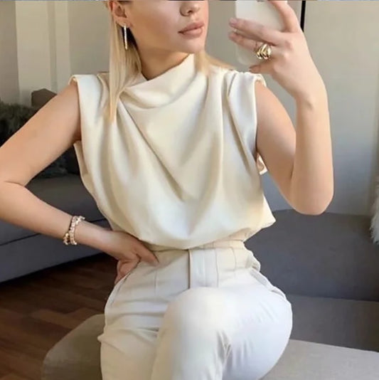Woman wearing a white outfit sitting on a couch with a blurred background