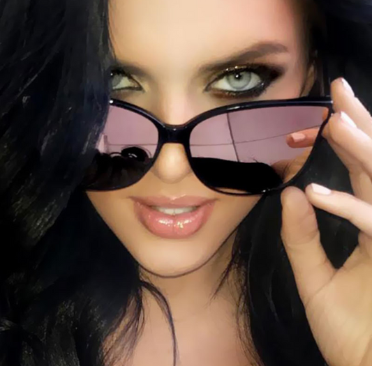 Close-up of a person wearing large black sunglasses with a blurred background