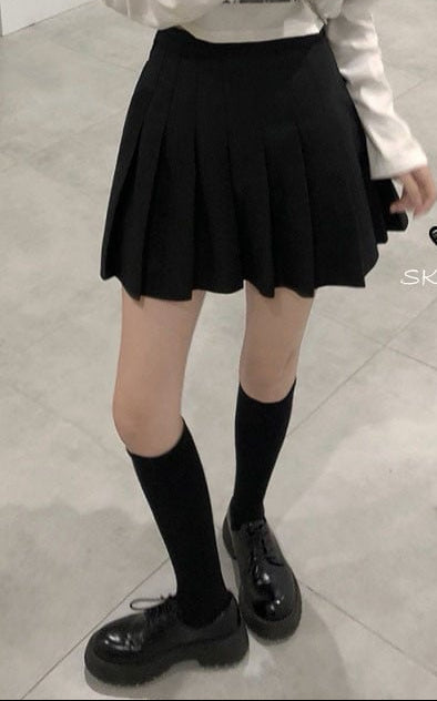 Two images showing a person wearing a black pleated skirt and a white pleated skirt with lace trim.