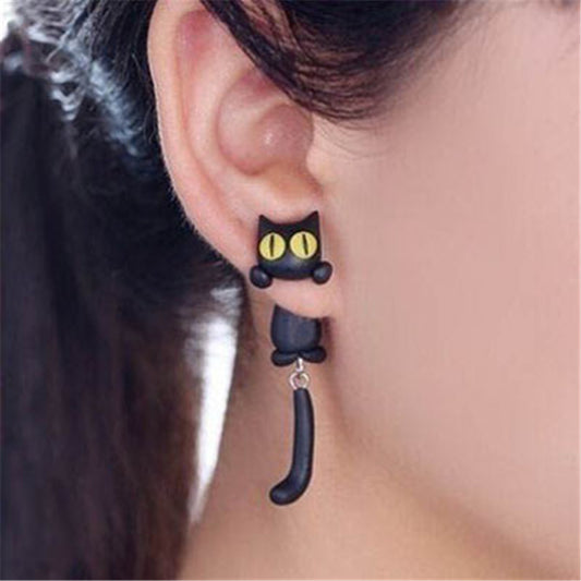 Black cat-shaped earrings worn by a person