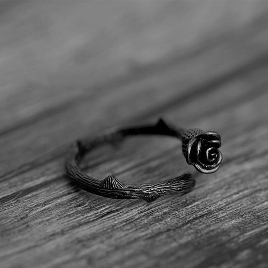 Silver ring with rose design on a wooden surface