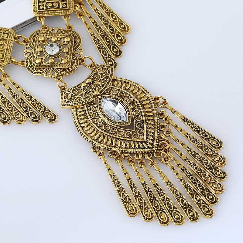 Watcher Eye gold-tone tassel necklace, ornate filigree close-up