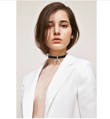 Person wearing a white blazer with a plain background