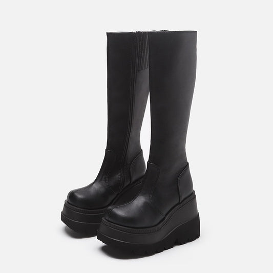 Black knee-high platform boots on a light gray background